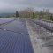 Fotovoltaické panely na střeše výrobní haly.